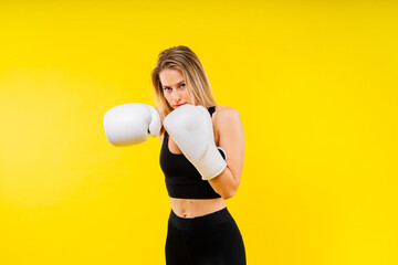 Female boxer hitting at a boxing studio. Woman in gloves training hard.