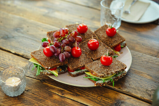 german black bread sandwich with cheese decorated with tomatoes on a plate