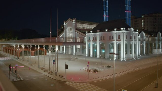 Building of the House of Culture GES-2 at night in Moscow, Russia. View near the river with a sculpture. High quality 4k footage