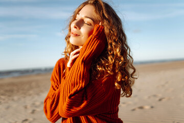 Outdoor portrait of pretty  woman on the beach  in cold sunny weather.  Travel, fashion, blogging...