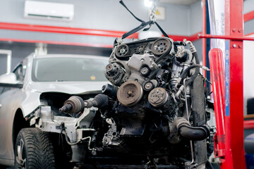 At the service station there is dirty motor in a suspended state for replacement of parts and repairs