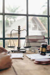 A lawyer explains to a client the law that must be applied to a court case. With contract documents and wooden gavel on the table in the courtroom Justice and law. Vertical image - obrazy, fototapety, plakaty