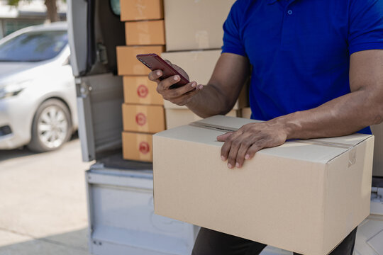 A person wearing a red T-shirt is delivering a package to a satisfied customer. friendly staff High quality courier service with cardboard boxes delivering parcels to customers. Courier delivers parce