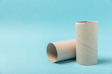 Empty toilet paper roll. Rolls of toilet paper on a blue background. Paper tube of toilet paper. Place for text. Copy space. Flat lay. Eco-friendly reuse recycle