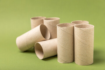 Empty toilet paper roll. Rolls of toilet paper on a green background. Paper tube of toilet paper. Place for text. Copy space. Flat lay. Eco-friendly reuse recycle