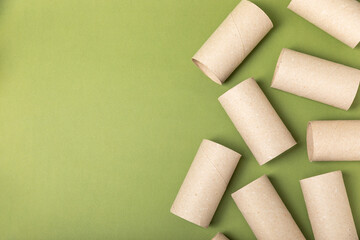 Empty toilet paper roll. Rolls of toilet paper on a green background. Paper tube of toilet paper. Place for text. Copy space. Flat lay. Eco-friendly reuse recycle