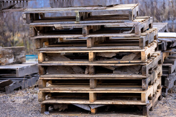 Broken shipping pallets stacked up at  an industrial warehouse site