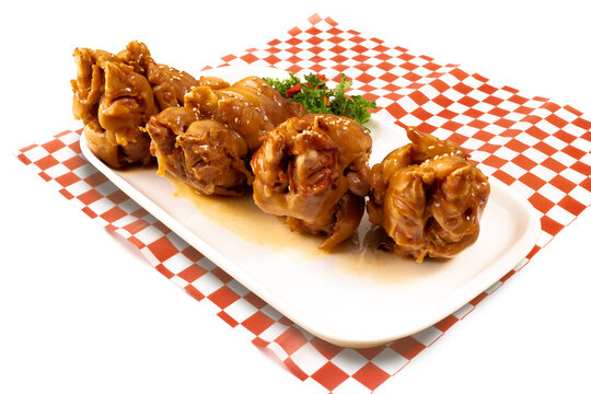 A plate of Chinese or Asian smoked pork hocks on a red checked table