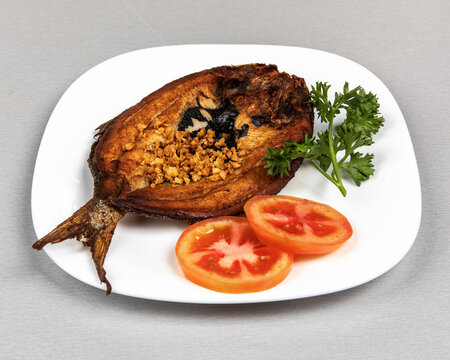 Fried Filipino milk fish, or Daing na Bangus, breakfast on a white plate