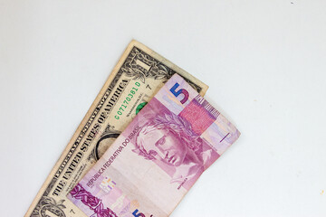 Nota de 1 dólar e 5 reais em papel isolados em fundo branco