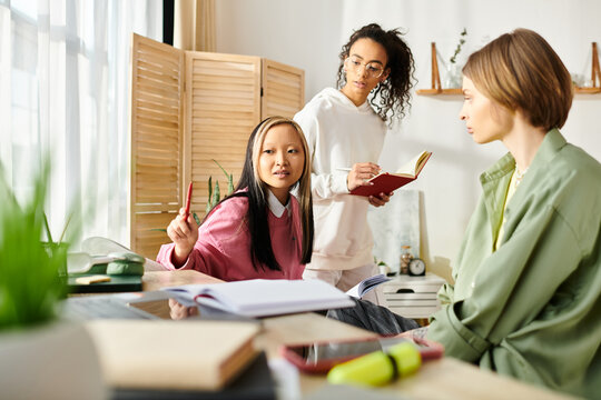 Diverse teenage girls, united in friendship, study together at a table, engaging in virtual learning from home. - Powered by Adobe