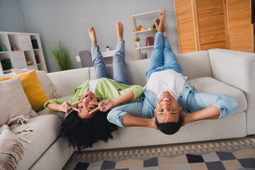 Photo of funky cool couple dressed casual outfits lying upside down having fun showing v-sing...