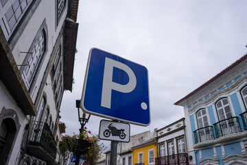 Motorcycle parking sign against a vibrant urban backdrop. Perfect for illustrating designated parking areas in cityscapes.