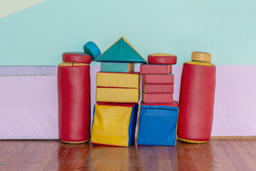 Colorful soft play equipment arranged in creative castle shape against pastel wall in playroom