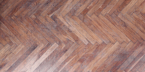 Detailed view of herringbone pattern wooden parquet floor with rich textures and tones. Classic...