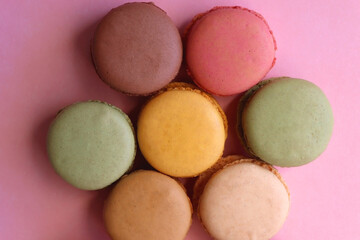 Colorful macarons on pink background. Top view.