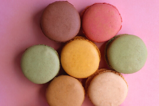 Colorful macarons on pink background. Top view.