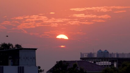 Experience nature's splendor with a vibrant sunset casting an orange hue over Dehradun City, Uttarakhand, India. Mesmerizing cloudscape completes the scene, offering a breathtaking dawn