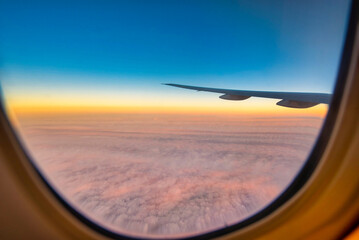 Silhouette wing of an airplane at sunset view through the window.
