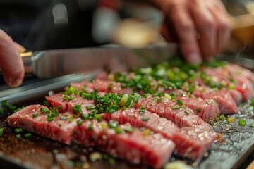 Close-up of marbled beef cuts seasoned with spring onions on a grill, with chef's hands in the background