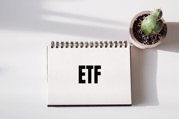 There is notebook with the word ETF or Exchange Traded Funds. It is as an eye-catching image.