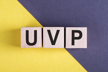 Wooden arrangement with the acronym UVP - Unique Value Proposition on yellow and gray background