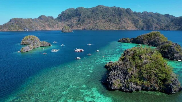 4K Aerial drone video of Siete Pecados Siete with boats surrounded by blue sea. Coron, Palawan. Philippines.