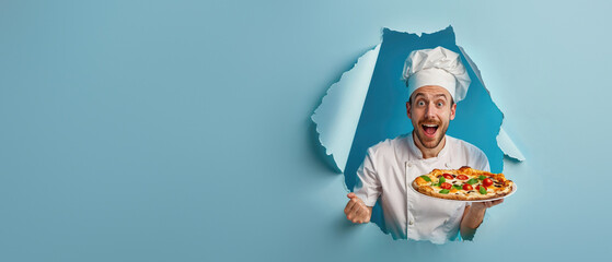 An enthusiastic chef displaying a fresh pizza appearing from a blue paper tear, creating a dynamic image