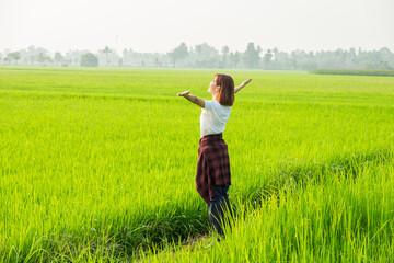 A woman joyfully jumps in a sunny field, surrounded by the beauty of nature, embodying freedom and...