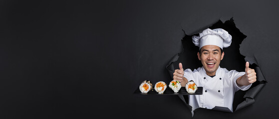 An ecstatic sushi chef in white gives thumbs up through a black torn background
