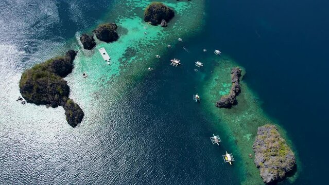 4K Aerial drone video of Siete Pecados Siete with boats surrounded by blue sea. Coron, Palawan. Philippines.