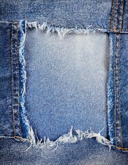  edge frame of blue denim ripped over jeans texture background 