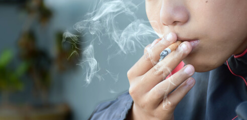 Closeup image of trying to smoke cigarette of teen which has a broken family concept, white smoke...