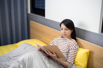 Woman read a notebook on bed