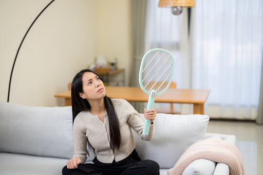 Woman use mosquito swatter at home