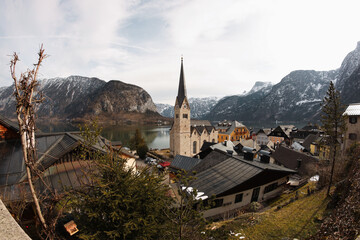 A beautiful view of Hallstatt town church, Austria, with the Alps in the background surrounding the...