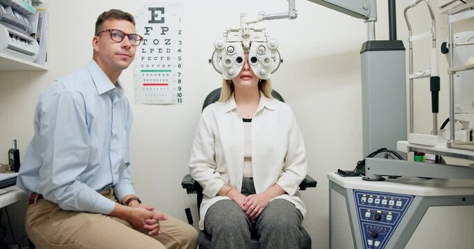 Ophthalmologist, man and woman in eye exam on phoropter for vision, healthcare or wellness in consultation. Medical test, optometry and patient on machine for eyesight or check with doctor in clinic