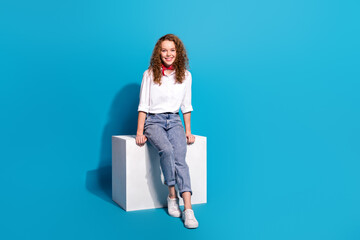 Photo portrait of nice young lady sit cube shopping banner wear trendy white garment isolated on blue color background