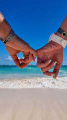 dwoje ludzi na plaży trzyma się za ręce, w oddali morze, słońce, fale - obrazy, fototapety, plakaty