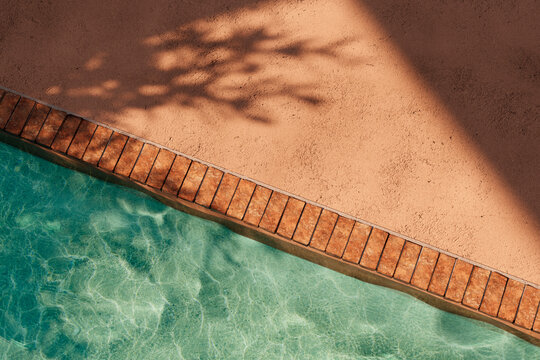 Top view of orange poolside in luxury hotel villa with sunlight shadow and swimming pool. Summer tropical background for product placement podium mockup.