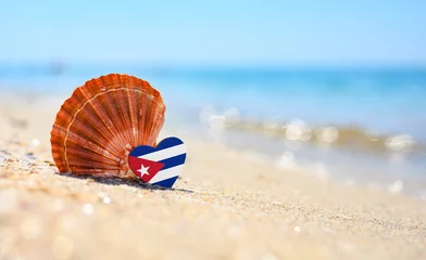 Zelfklevend Fotobehang Sandy beach in Cuba. Cuba flag in the shape of a heart and a large shell. A wonderful resort on the Caribbean Sea © Nikita