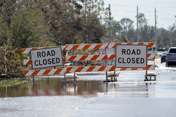 Road closed for roadworks and danger of flooding with warning signs blocking driving of cars