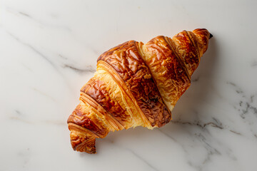 Golden Flaky Croissant on a Marble Surface Close-Up - obrazy, fototapety, plakaty