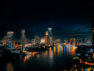 Fototapeta na wymiar Beautiful architecture in Bangkok City skyline at night Filter effect Chao Phraya riverside at night, office buildings, Cityscape, night view in the business district at twilight capital of Thailand.