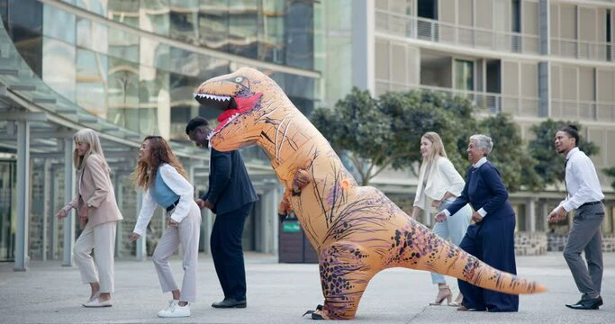 Business, people and dance in costume outdoor with fun inflatable dinosaur and happiness at office. Funny, group and crazy team building performance at work with excited energy or comedy character