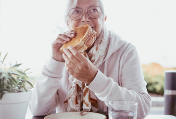 Serene elderly Caucasian woman while preparing to eat a french toast, lonely grandmother sitting...