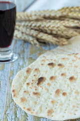 Christian Passover food, unleavened bread and wine with ripe wheat on wooden table. Close-up. Biblical concept.