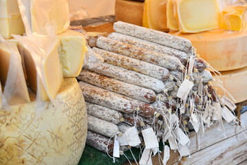 Farm stall with cheese wheels and smoked sausage at the fair