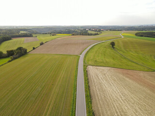 View from above of a road between fields in the farmland 