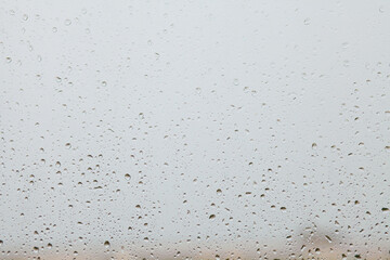 Raindrops on window glass. Rain outside window. Cloudy day. Rainy weather. Background with raindrops on window. Raindrops close up. Depression concept.